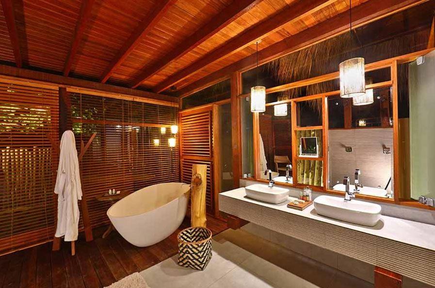 Banheira de imersão em banheiro amadeirado com detalhes em branco.