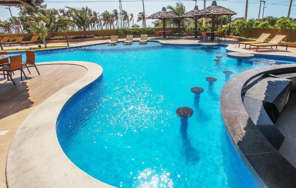 Piscina com bar molhado e espreguiçadeiras, pousadas na praia do futuro.