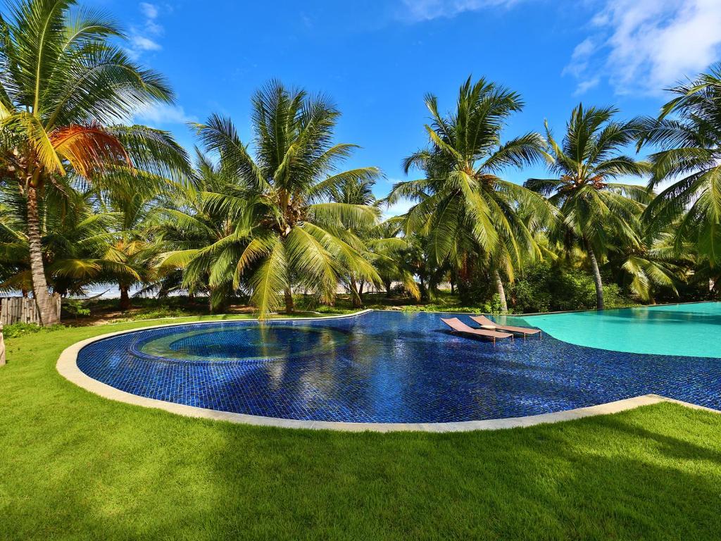 Piscina ampla em jardim com coqueiros em pousadas para casal perto de Maceió.