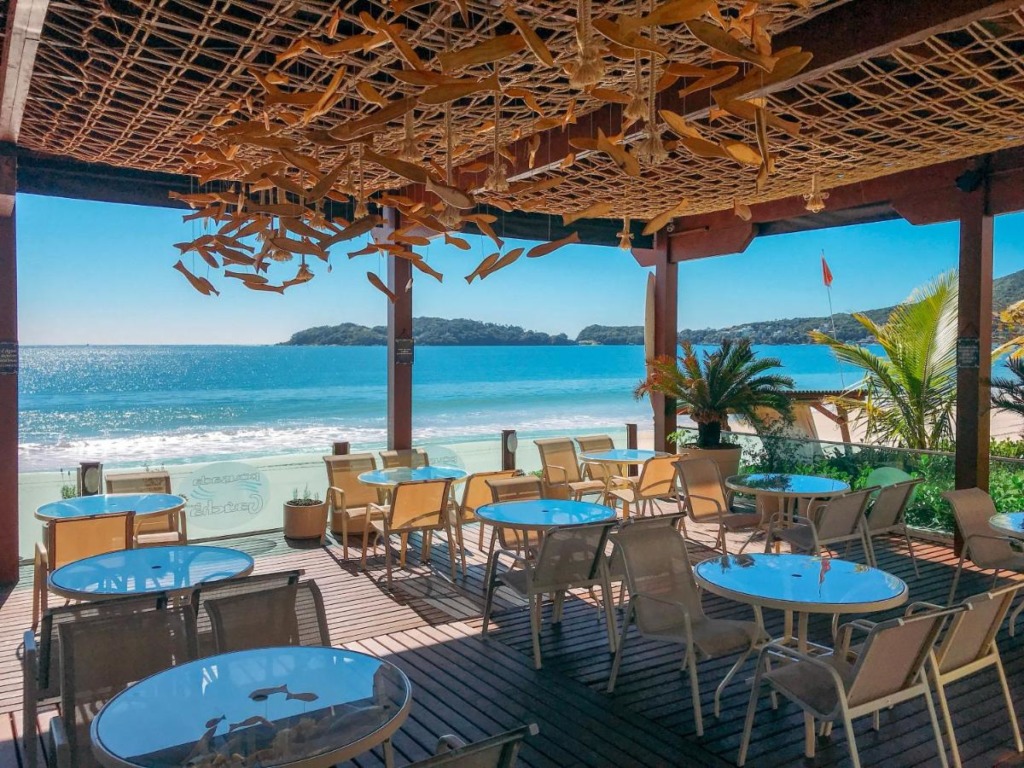 Restaurante em deck de madeira, com vista para o mar. Pousadas pé na areia em Bombinhas.