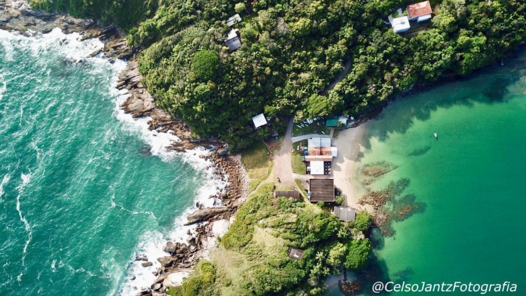 Vista aérea com o Paraíso das Tartarugas no meio e duas praias abraçando-a. 