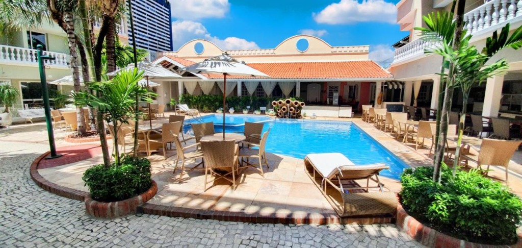 Ampla piscina rodeada por prédio com varandas, em hotéis na praia do futuro.