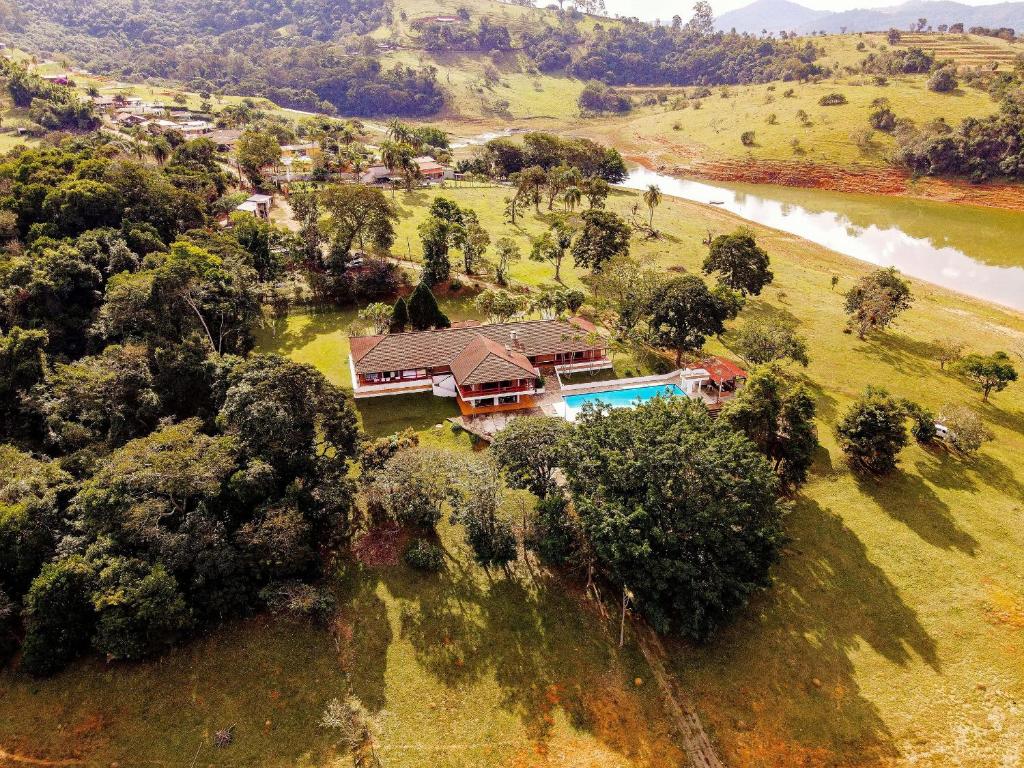 Vista aérea de sítio perto da represa, com detalhe para a piscina e varandas na casa.