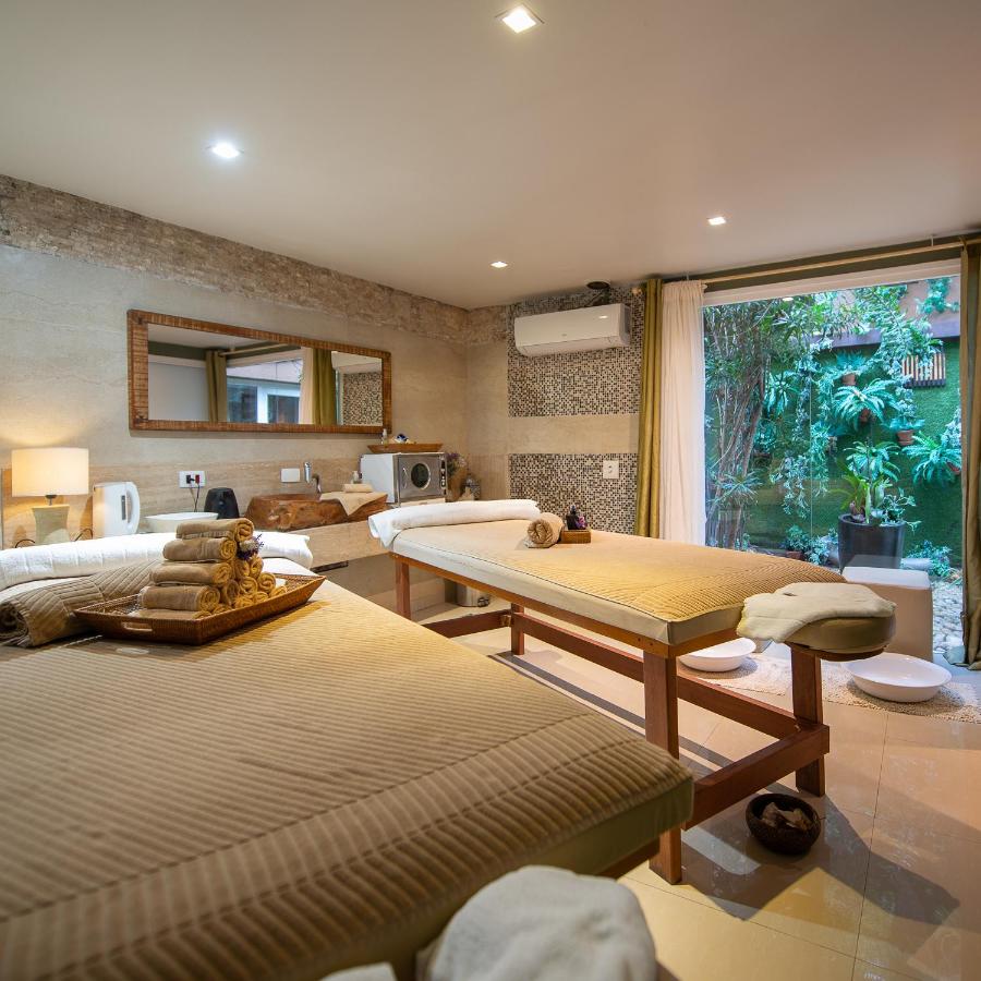Área de spa com duas camas de massagem, ar-condicionado, pia em pousadas perto da praia da Baleia.